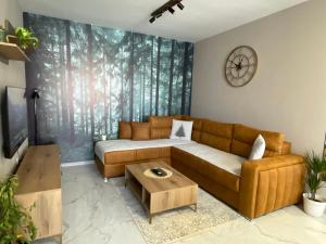 a living room with a couch and a coffee table at Apartman Green Oaza in Vrbas