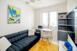 a living room with a black couch and a desk at Apartament Staymonte in Wrocław +14 photos
