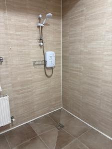 a bathroom with a shower with a shower head at Carey's Bar & Farmhouse Kilkenny Border in Oldleighlin +16 photos