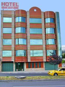 a hotel with a yellow car parked in front of it at Hotel Gran Quitumbe in Quito