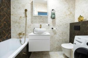 a bathroom with a sink and a tub and a toilet at Apartament Staymonte in Wrocław