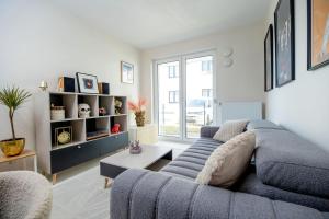 a living room with a blue couch and a table at Apartament Staymonte in Wrocław