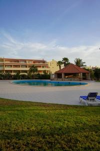 a pool with a chair and a building in the background at Apartamento Paradise beach in Prainha