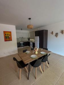 a kitchen with a wooden table and some chairs at Apartamento Paradise beach in Prainha