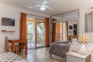 a bedroom with a bed and a desk and a balcony at Villa Baya in Bayahibe