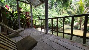 a porch with a bench sitting on a wooden deck at Centro Ecoturistico Ya´ajche in Lacanjá