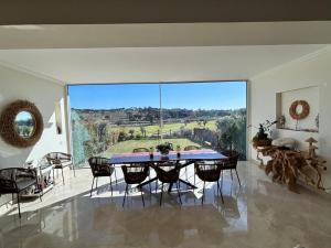 a dining room with a table and chairs and a large window at Formosa Villas in Quinta do Lago