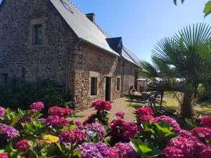 an old stone church with flowers in front of it at Gîte Le Petit Menhir in Trans