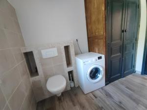 a bathroom with a washing machine and a toilet at Gîte Le Petit Menhir in Trans +30 photos