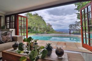 a living room with a pool and a large window at Panorama View Pool House Steiltes I in Nelspruit