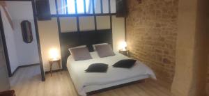 a bedroom with a white bed with two pillows at Gîte Le Petit Menhir in Trans