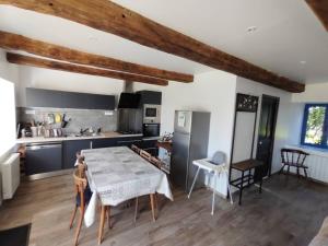 a kitchen with a table and chairs in a room at Gîte Le Petit Menhir in Trans