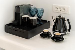 a counter with two cups of coffee and a tea kettle at Galation in Mikonos