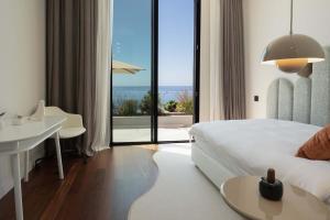 a bedroom with a bed and a table and a desk at Villa Anjos - Luxury Villa with Infinity Pool & Ocean View in Canhas +52 photos