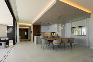 a dining room and kitchen with a table and chairs at Villa Anjos - Luxury Villa with Infinity Pool & Ocean View in Canhas