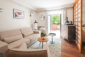 a living room with a couch and a table at Hotel La Mandarine Saint Tropez in Saint-Tropez