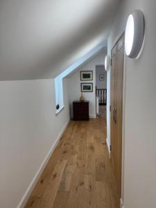 a hallway with white walls and a wooden floor at Crannach House bed and breakfast and self catering apartments in Ballater
