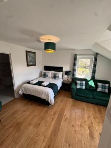 a bedroom with a bed and a green couch at Crannach House bed and breakfast and self catering apartments in Ballater