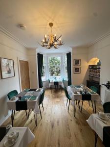 a dining room with tables and chairs and a chandelier at Crannach House bed and breakfast and self catering apartments in Ballater