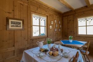 a dining room with two tables and two windows at Maso Scricciolo Farm House in Vezzano