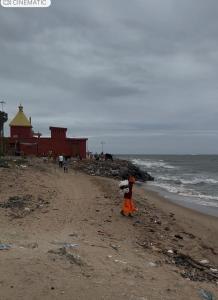 a child walking on a beach near the ocean at Jacobs Cottage KG-F2 in Thiruchendur