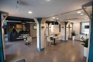 a restaurant with tables and chairs and a kitchen at Pensiunea Panorama Business Inn in Cluj-Napoca