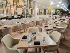 a restaurant with wooden tables and chairs and tablesearcher at MS Milenium Monterrey Curio Collection by Hilton in Monterrey