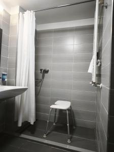 a bathroom with a shower and a stool in it at Pensiunea Panorama Business Inn in Cluj-Napoca +30 photos