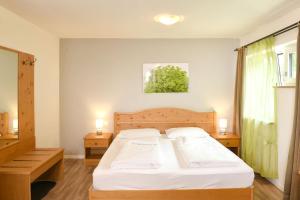 a bedroom with a bed with white sheets and two lamps at Texel Apartments in Madonna