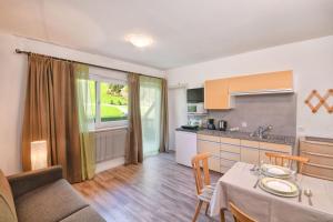 a kitchen and living room with a table and a couch at Texel Apartments in Madonna