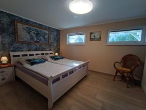 a bedroom with a large bed and two windows at Ferienwohnung Ankerplatz Züssow in Züssow