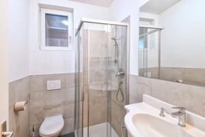 a bathroom with a shower and a toilet and a sink at Texel Apartments in Madonna