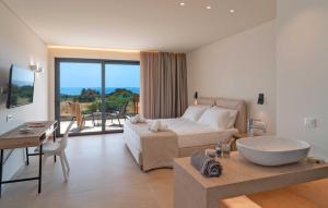 a bedroom with a bed and a bathroom with a tub at Aethrion Villas & Suites in Gennadi