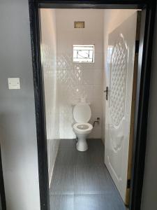 a bathroom with a white toilet in a room at Ramachi apartments in Livingstone +16 photos