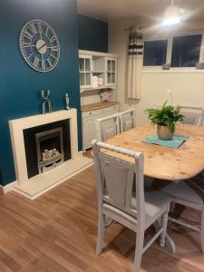 a dining room with a table and a clock on the wall at Dream view holiday home in Castletown