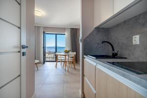 a kitchen with a sink and a table with a view at Wind Rose Bura-beachfront in Igrane