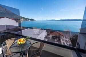 a table with a bowl of fruit on a balcony at Wind Rose Bura-beachfront in Igrane