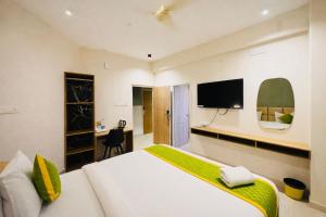 a bedroom with a large bed and a flat screen tv at Elegant Residency in Coimbatore
