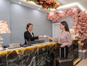 two women standing at a reception desk with a card at Bond Hotel in Istanbul