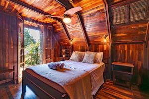 a bedroom with a bed in a room with a window at Rosa Chalé do Vô Walter in Gramado