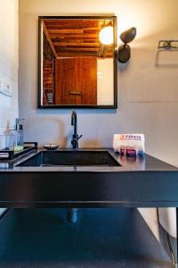 a kitchen counter with a sink and a mirror at Rosa Chalé do Vô Walter in Gramado +46 photos