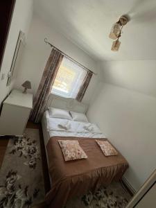 a small bedroom with a bed and a window at Cabana Bianca & Iair in Poiana Vadului