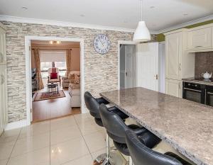 a kitchen with a large counter and chairs at Sleepy Rock in Dungarvan +8 photos