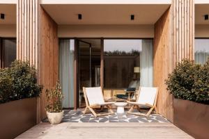a pair of chairs and a table on a patio at Aethos Hotel Ericeira in Ericeira