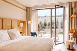 a hotel room with a bed and a balcony at Aethos Hotel Ericeira in Ericeira