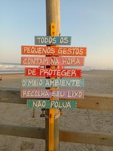 a sign on a pole at the beach at Cabanas Sol e Lua in Imbé