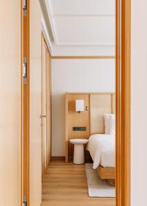 a bedroom with a white bed and a white table at Aethos Hotel Ericeira in Ericeira