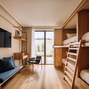 a room with bunk beds and a desk and a chair at Aethos Hotel Ericeira in Ericeira