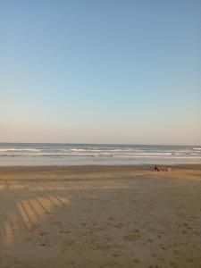 a group of people riding horses on the beach at Cabanas Sol e Lua in Imbé