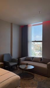 a hotel room with a couch and a window at فندق جولدن نيو سمارت لاكجري - Golden New Smart Hoteluxury in Abha